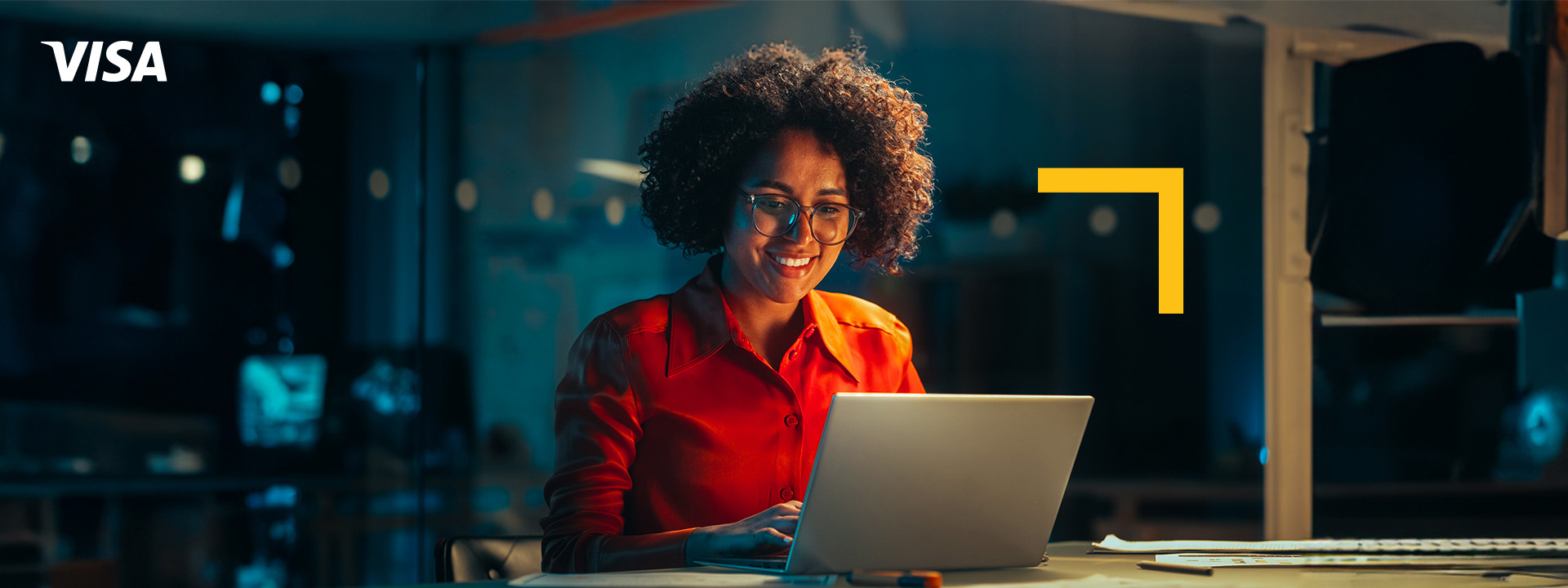 Woman working on a laptop late at night in an office