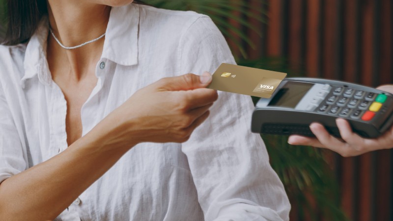 A woman paying with her Visa Gold card