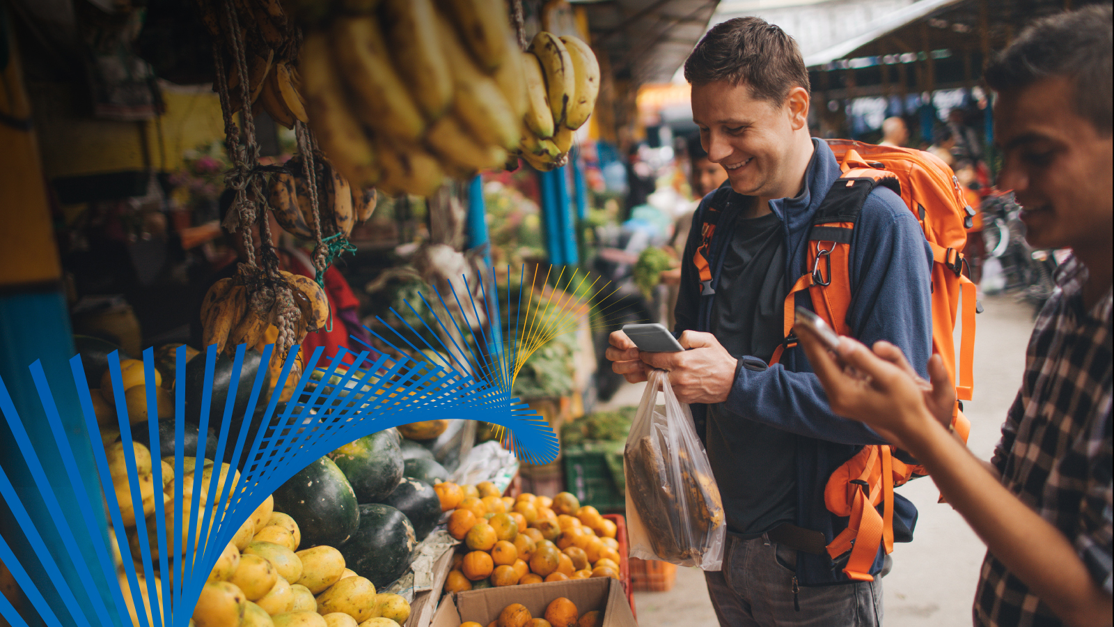 Man buying fruit using his mobile phone at an outdoor market.